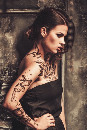 Tattooed beautiful woman in old spooky interiorの写真素材