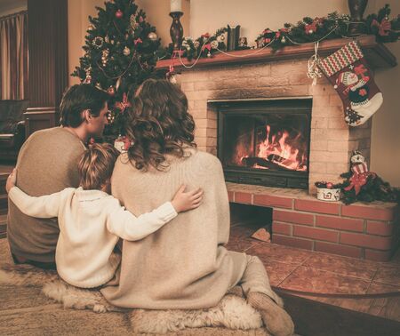 Family near fireplace in Christmas decorated house の写真素材