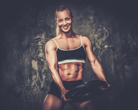 Beautiful muscular bodybuilder woman with weightsの写真素材