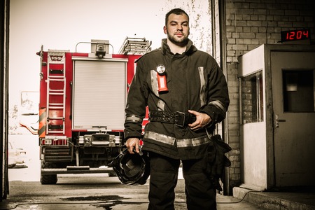 Firefighter against truck in firefighting depot