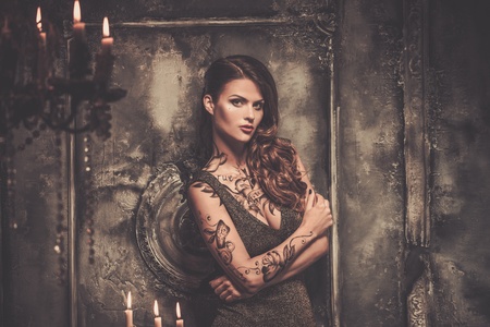 Tattooed beautiful woman in old spooky interiorの写真素材