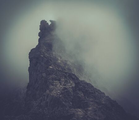 Fog over high mountain peakの写真素材