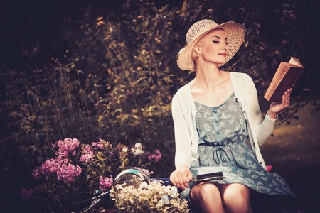 Beautiful blond woman sitting on a retro rollerの写真素材