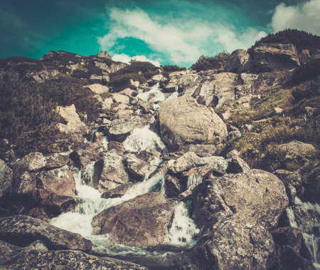 Stream running through rocks in a mountainsの写真素材