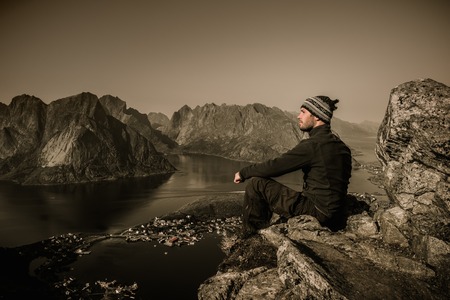 Man hiker looking at Reine village panorama, Norwayの写真素材