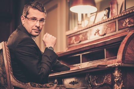 Confident middle-aged man in luxury vintage style interiorの写真素材