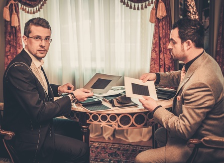 Tailor and client choosing cloth and buttons for custom made suitの写真素材