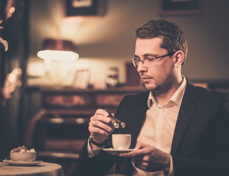 Middle-aged with cup of coffee in luxury vintage style interiorの写真素材