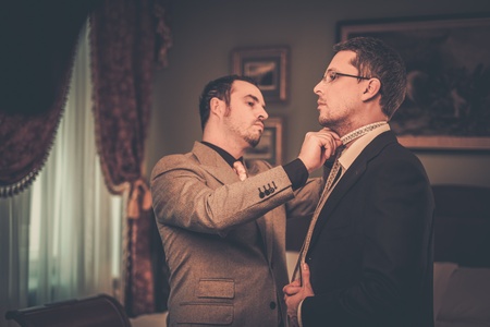 Tailor and client choosing cloth and buttons for custom made suitの写真素材