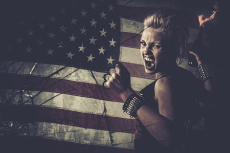 Punk girl against USA flag with brass knuckles and Molotov cocktailの写真素材