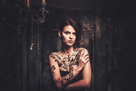 Tattooed beautiful woman in old spooky interiorの写真素材