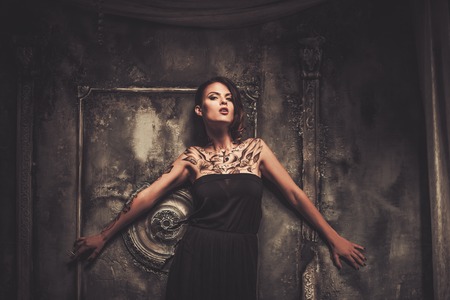 Tattooed beautiful woman in old spooky interiorの写真素材