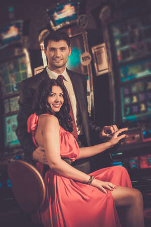 Beautiful couple near slot machine in a casinoの写真素材