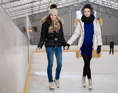Two girls on ice-skating rinkの写真素材
