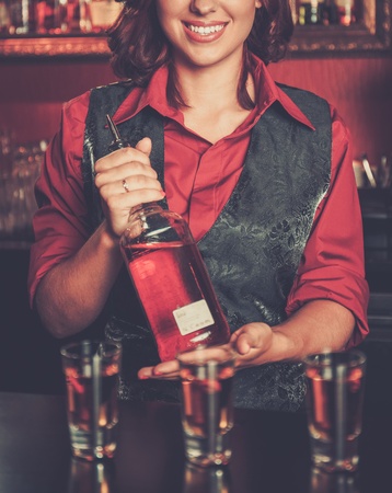 Beautiful redhead barmaid making shotsの写真素材