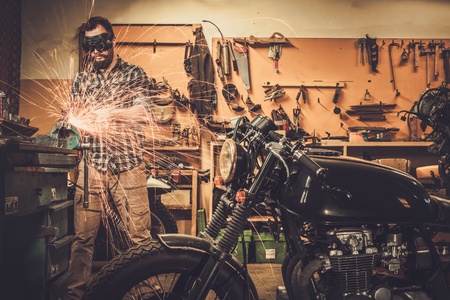 Mechanic doing lathe works in motorcycle customs garage