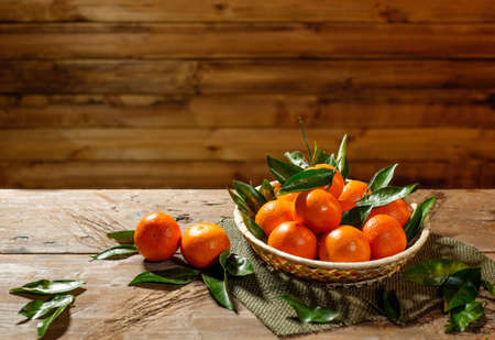 Basket with tasty tangerines on a wooden tableの写真素材