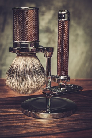 Safety razor and shaving brush on a standの写真素材