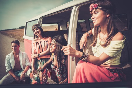 Multi-ethnic hippie friends with guitar on a road tripの写真素材
