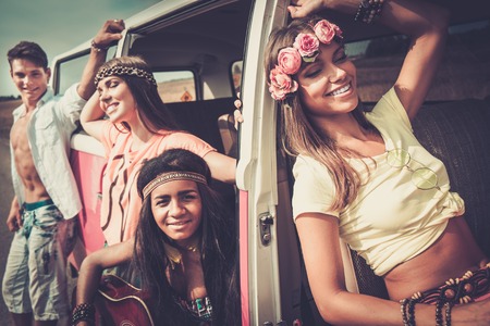 Multi-ethnic hippie friends with guitar on a road tripの写真素材