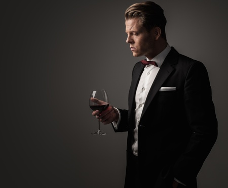 Confident sharp dressed man with glass of wineの写真素材