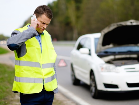 Man calling car towing service on a highway roadsideの写真素材