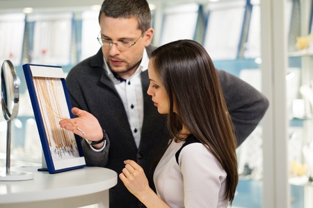 Woman with assistant help choosing jewelleryの写真素材