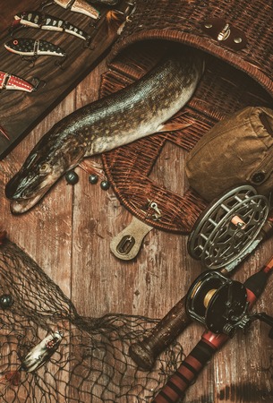 Fishing tools and fresh pike on a wooden tableの写真素材
