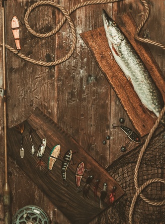 Fishing tools and fresh pike on a wooden tableの写真素材