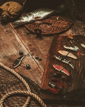 Fishing tools and fresh pike on a wooden tableの写真素材