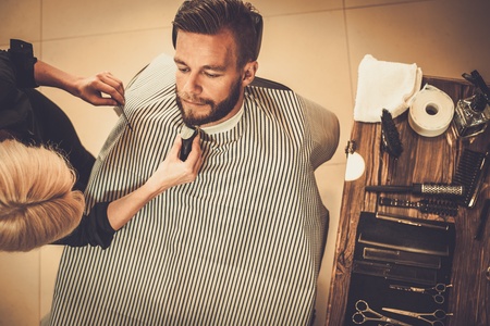 Client during beard and moustache grooming in barber shopの写真素材