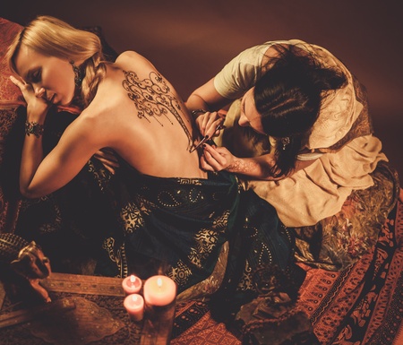 Drawing process of henna menhdi ornament on woman's backの写真素材