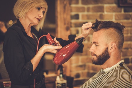 Client visiting hairstylist in barber shopの写真素材