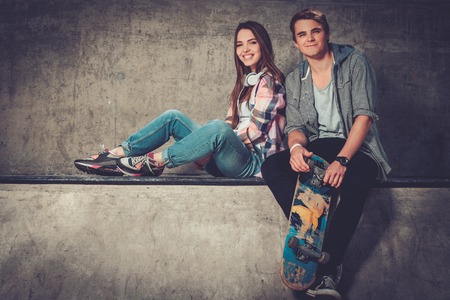 Young couple with skateboard outdoorsの写真素材