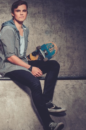 Handsome young man with skateboard outdoorsの写真素材