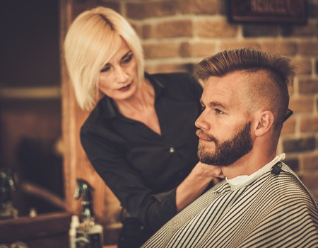 Client visiting hairstylist in barber shopの写真素材