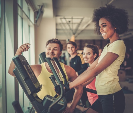 Trainer explaining how to use elliptical training machineの写真素材