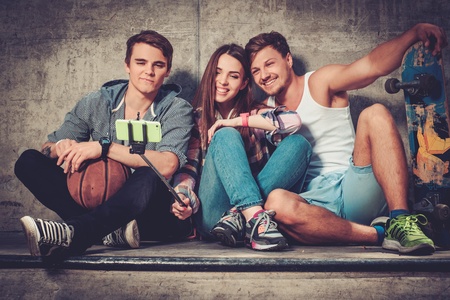 Cheerful friends with with skateboard taking selfie outdoorsの写真素材