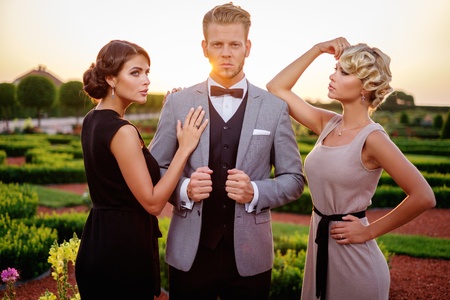 Well-dressed wealthy friends in a beautiful parkの写真素材