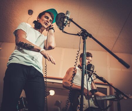 Music band performing in a recording studioの写真素材