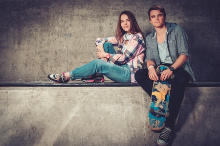 Young couple with skateboard and skates outdoorsの写真素材