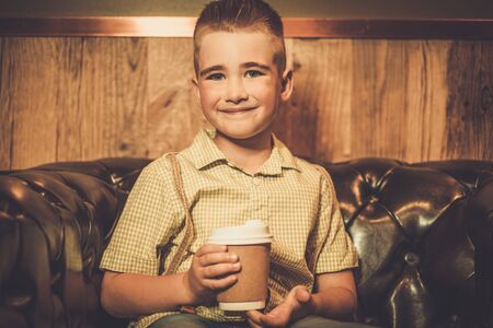 Stylish little boy with coffee mugの写真素材