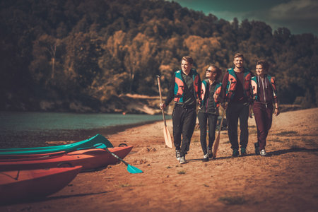 Group of people wearing life jackets near kayaks on a beachの写真素材