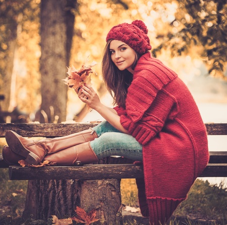 Beautiful woman wearing knitted coat in autumn parkの写真素材