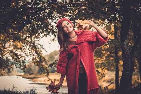 Beautiful woman wearing knitted coat in autumn parkの写真素材