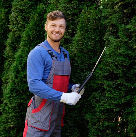 Young gardener cutting trees with clippers