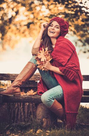 Beautiful woman wearing knitted coat in autumn parkの写真素材