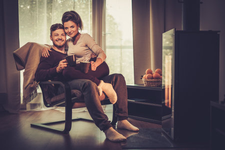 Young couple near fireplace at homeの写真素材