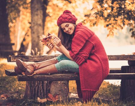 Beautiful woman wearing knitted coat in autumn parkの写真素材