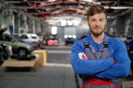Cheerful serviceman in a car workshop